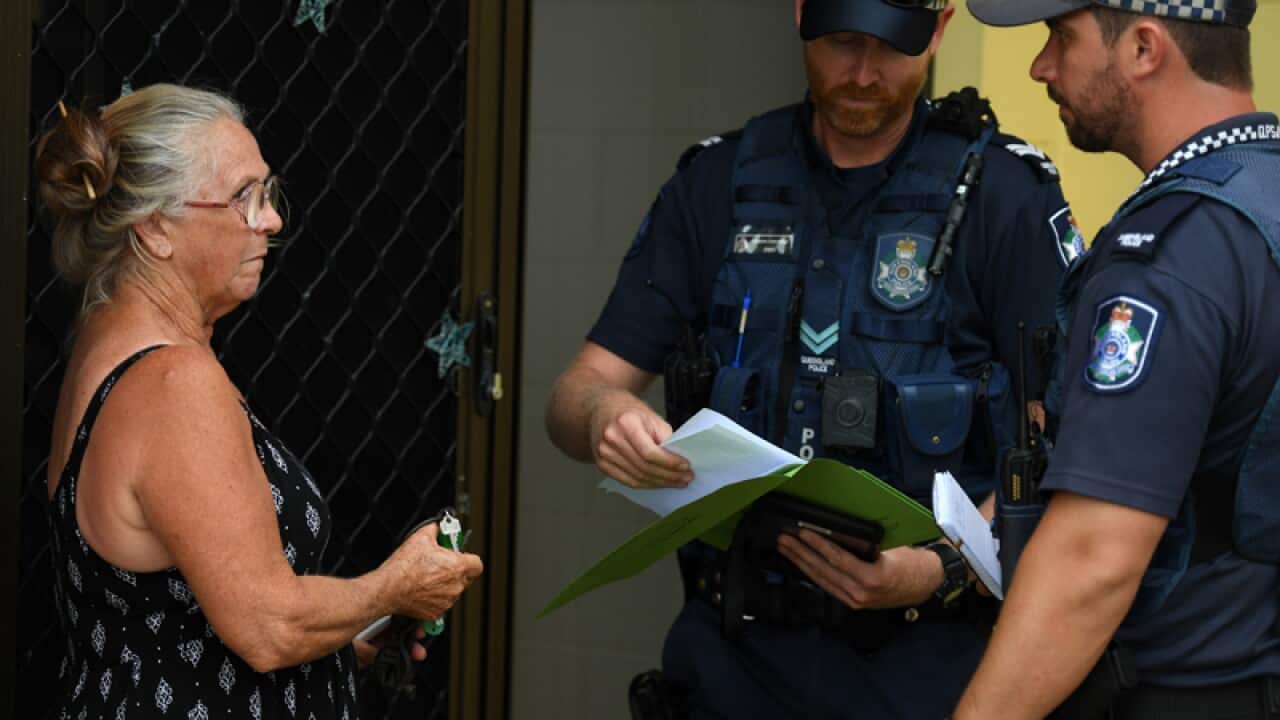 Resident advising police officers that she will not evacuate her house