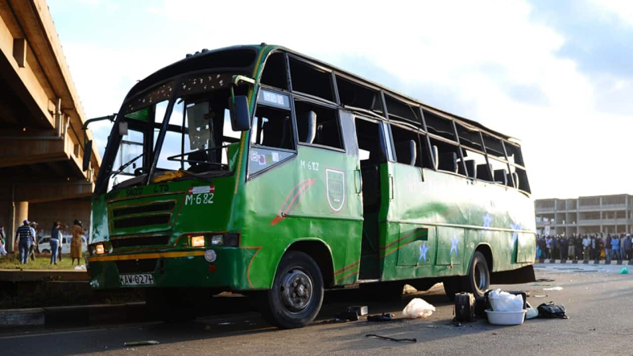 Luggage lies on the road outside a damaged bus