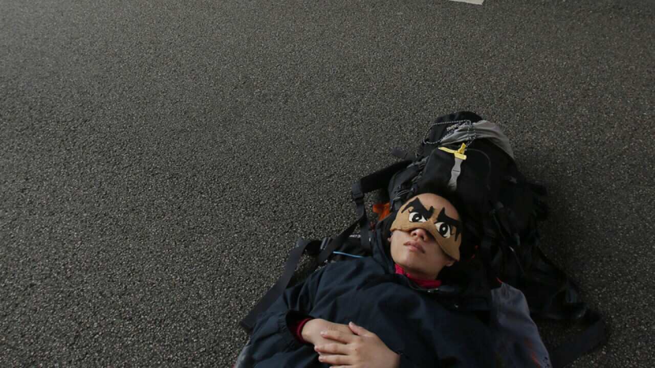 a pro-democracy student protester sleeps on an occupied roadway