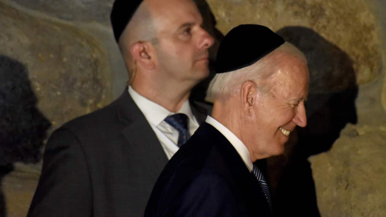 Two men in suits smiling.