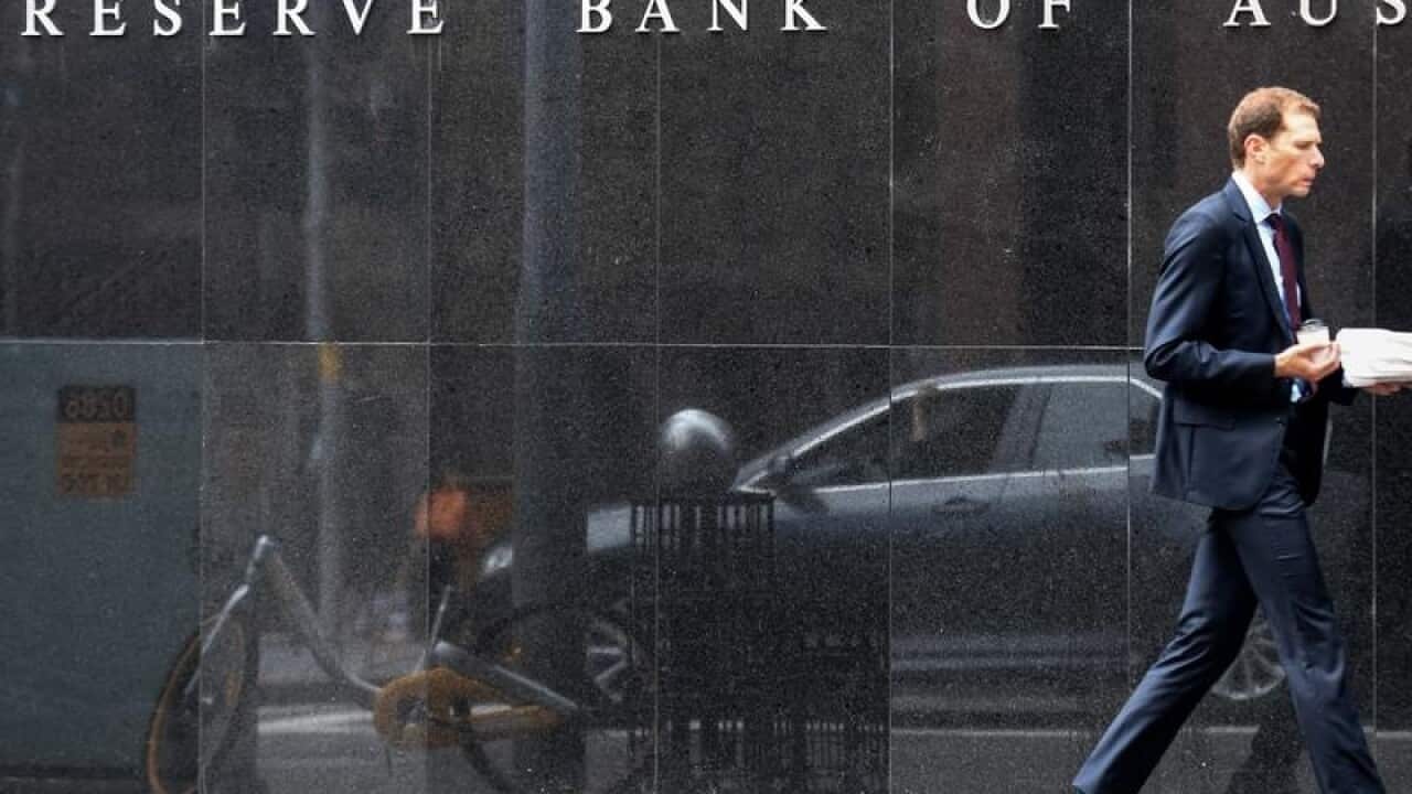 A file image of a man walking by Reserve Bank of Australia, Sydney.