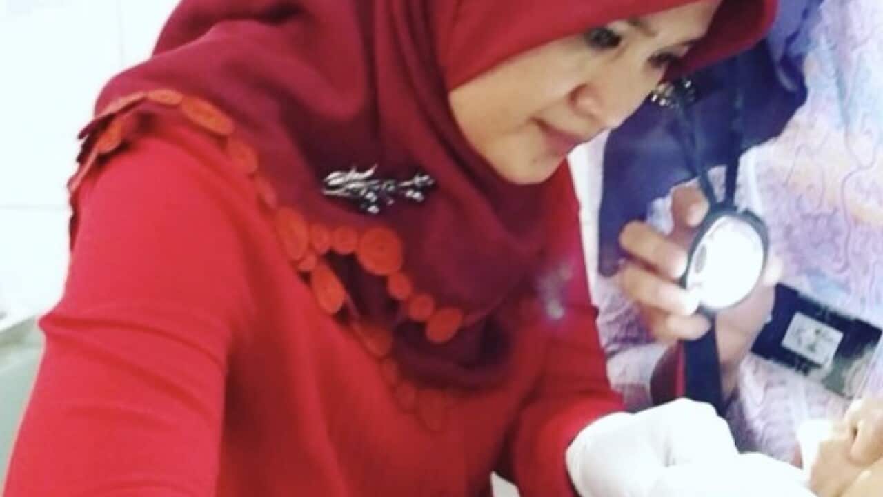 Dr Elizabeth Fitriana Sari examining a patient for mouth cancer, Bandung 2021.