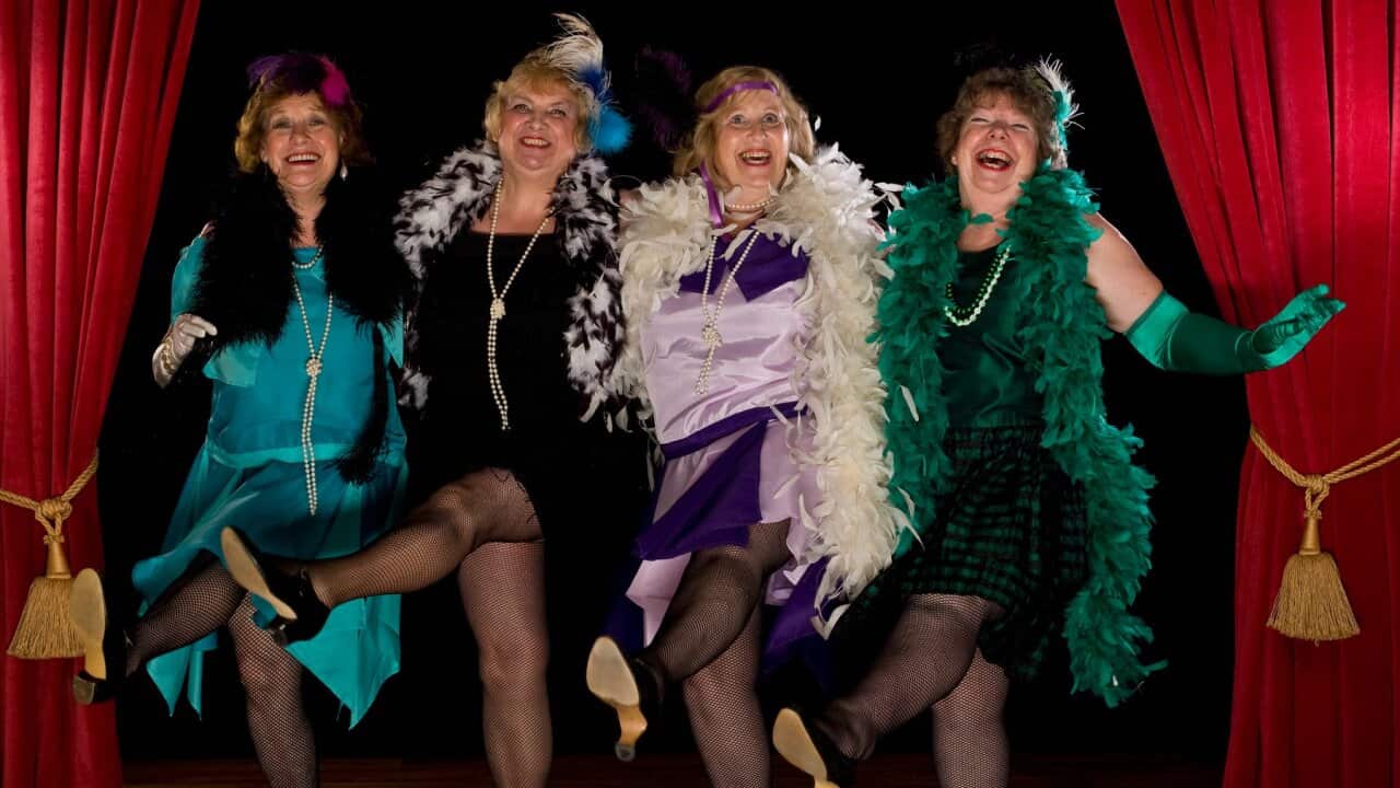 Group of senior women performing on stage, laughing, portrait