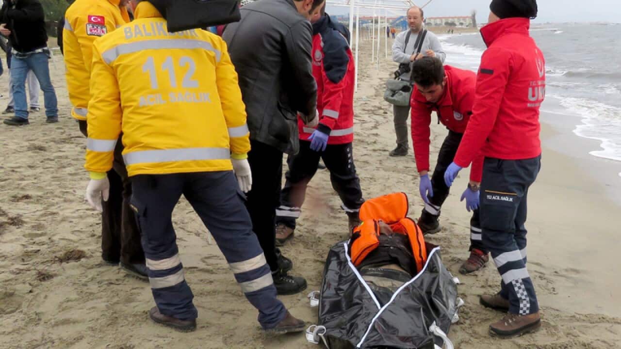 People carry the body of a refugee that drowned off the Turkish coast