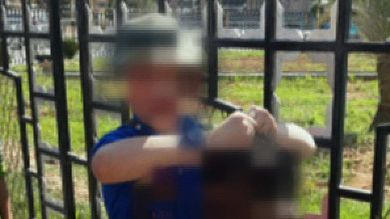 Pixelated image of boy holding up the decapitated head of a slain Syrian soldier.