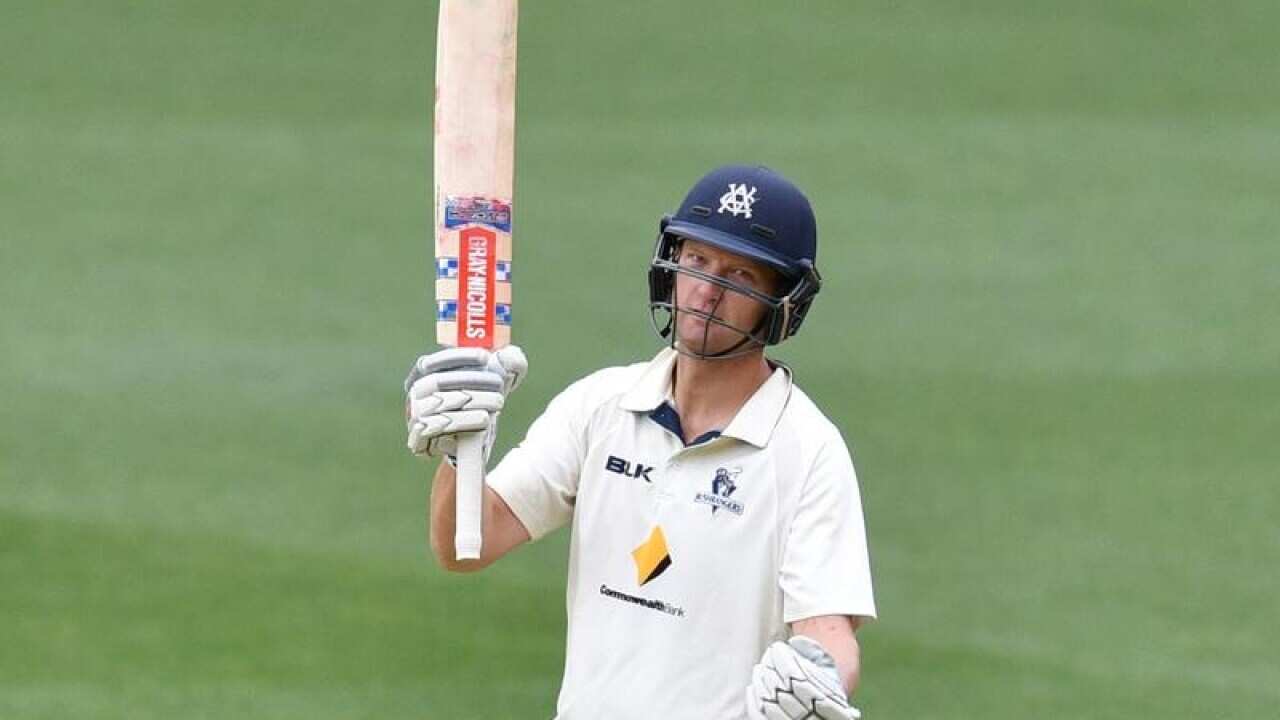 Victorian batsman Cameron White raises his bat after scoring a century