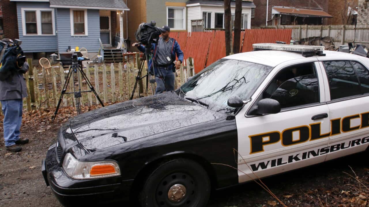 Wilkinsburg police drive past the scene of a deadly shooting