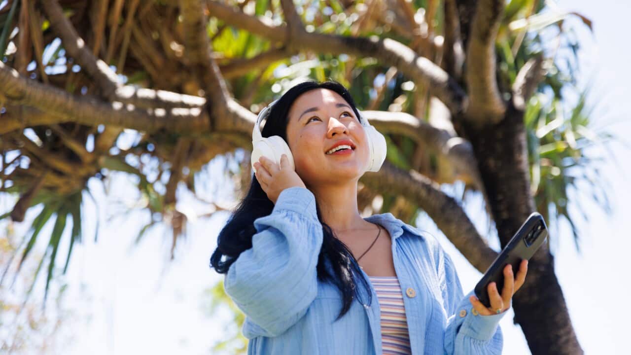 Woman connecting to smartphone and listening to music in beautiful natural setting