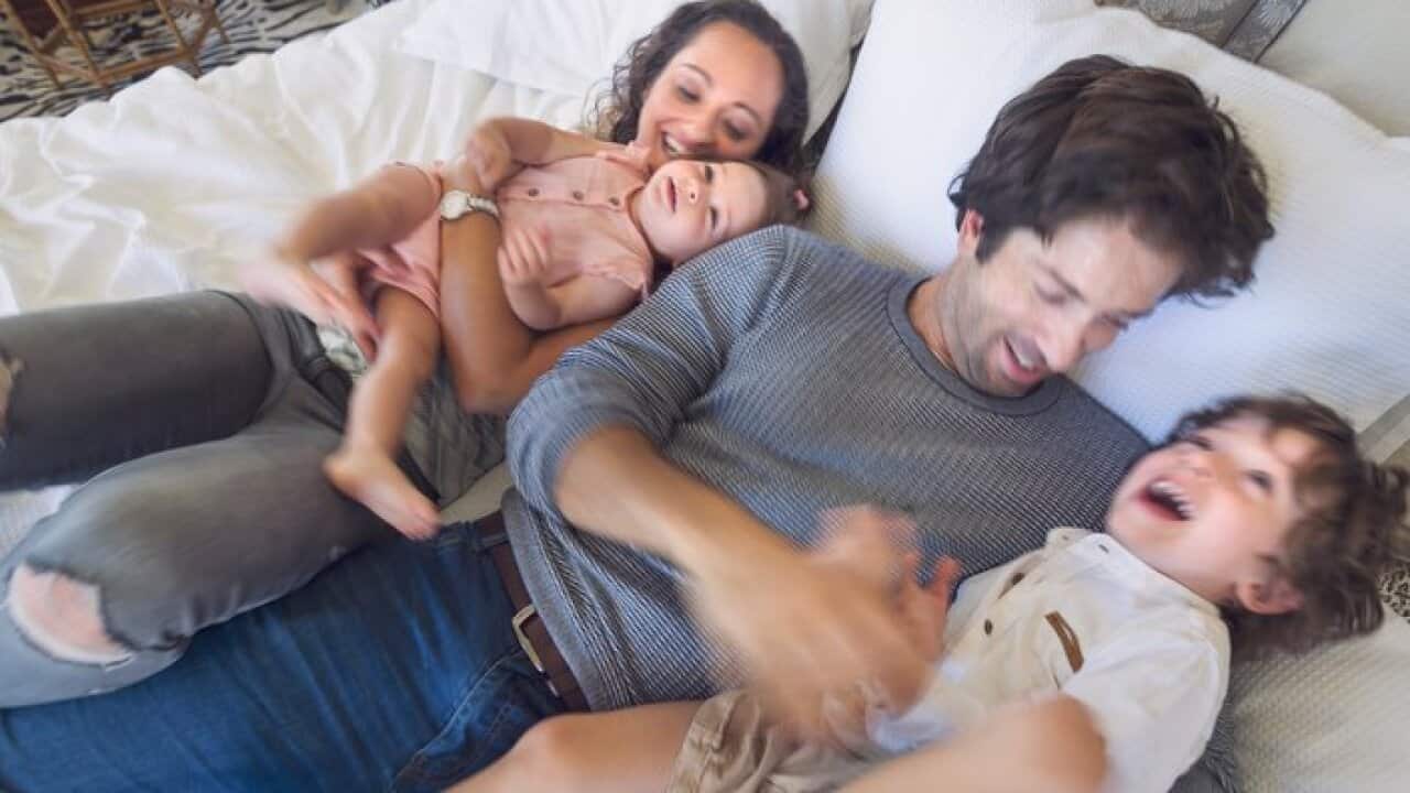 Family playing on the bed