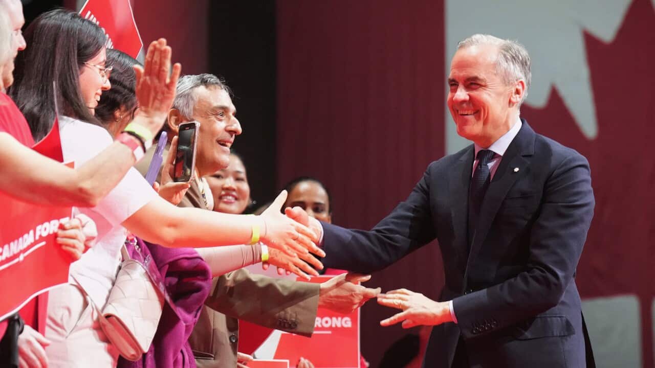 Canadian Prime Minister Mark Carney greets attendees as he arrives to address supporters at his campaign headquarters on election night in Ottawa