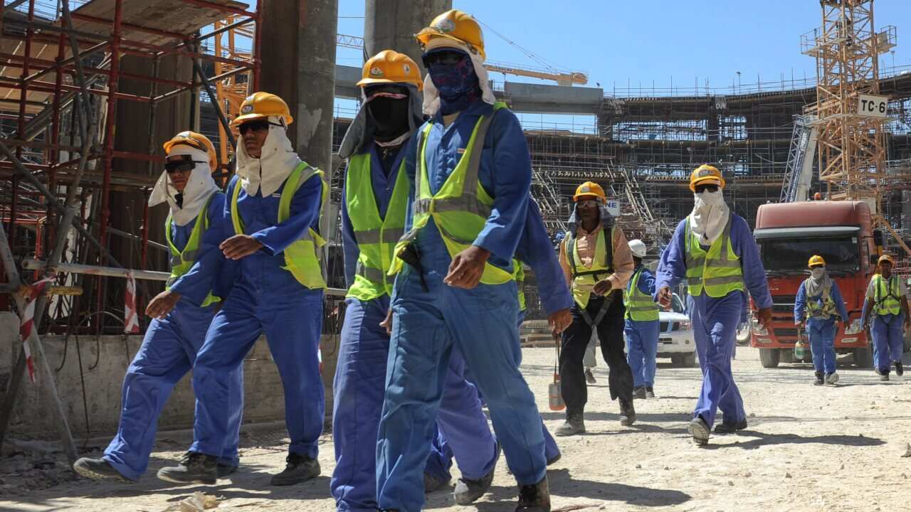 Foreign construction workers leave a construction site in Doha, Qatar.
