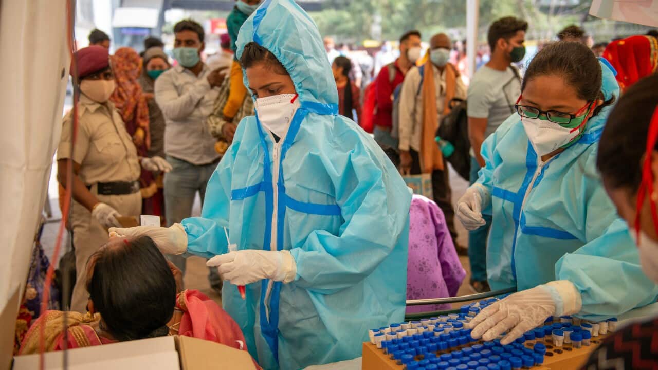 A health worker collects a swab sample from a woman during the RT PCR test from a Covid-19 testing center at Anand Vihar.