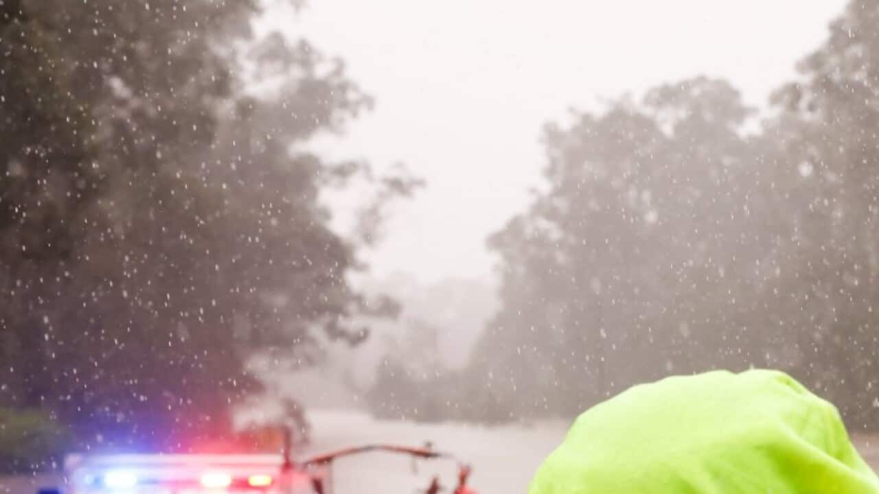 A man talks to police after he was rescued from his submerged car by State Emergency Service workers in Windsor on July 04, 2022 in Sydney, Australia. Jenny Evans/Getty Images