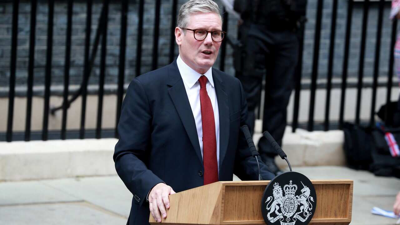 A man in a navy blue suit white shirt and red tie