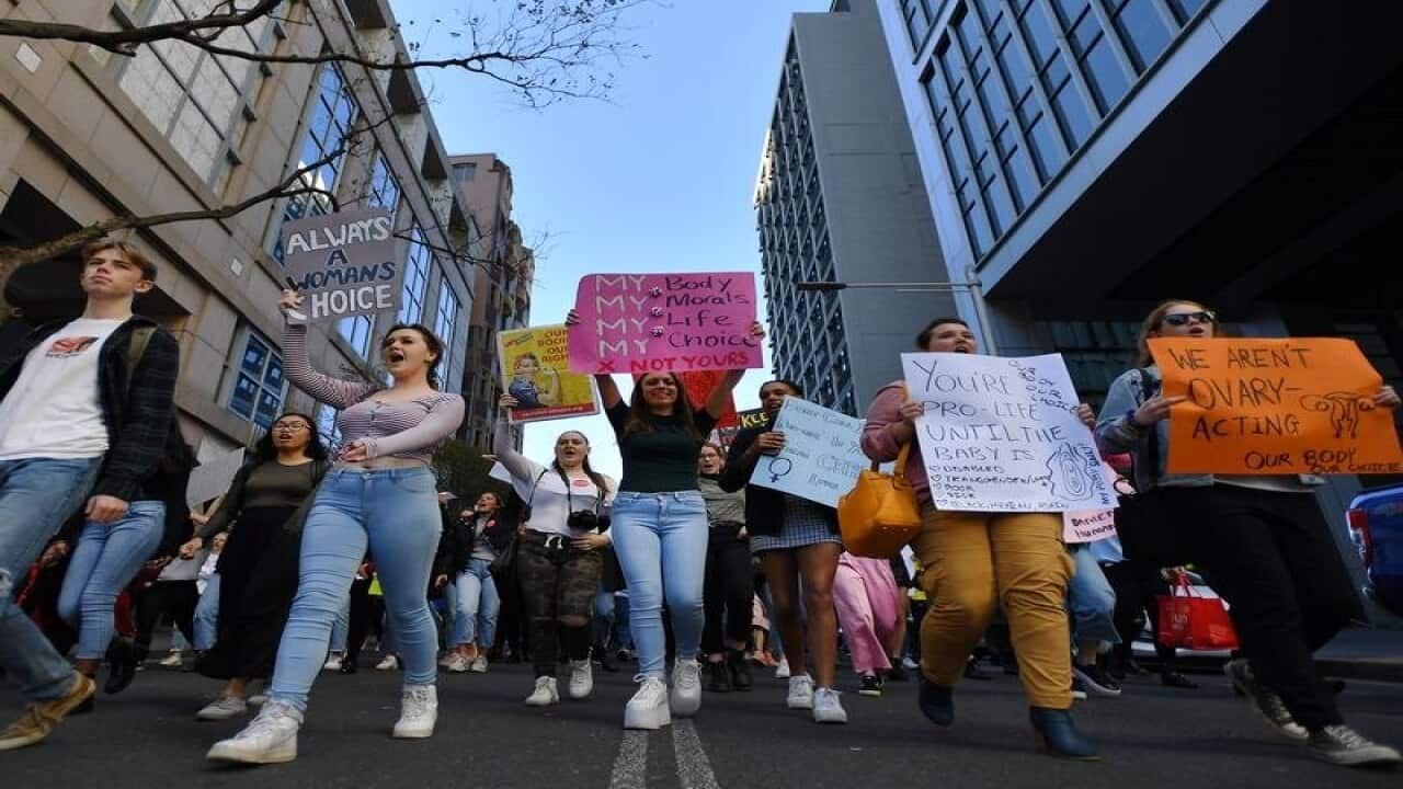 Protesters hold placards during the Our Body Our Choice march