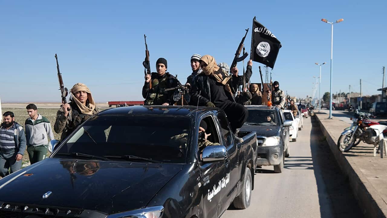 In this photo released on May 4, 2015, by a militant website, Islamic State militants pass by a convoy in Tel Abyad town, northeast Syria. (Militant website via AP)