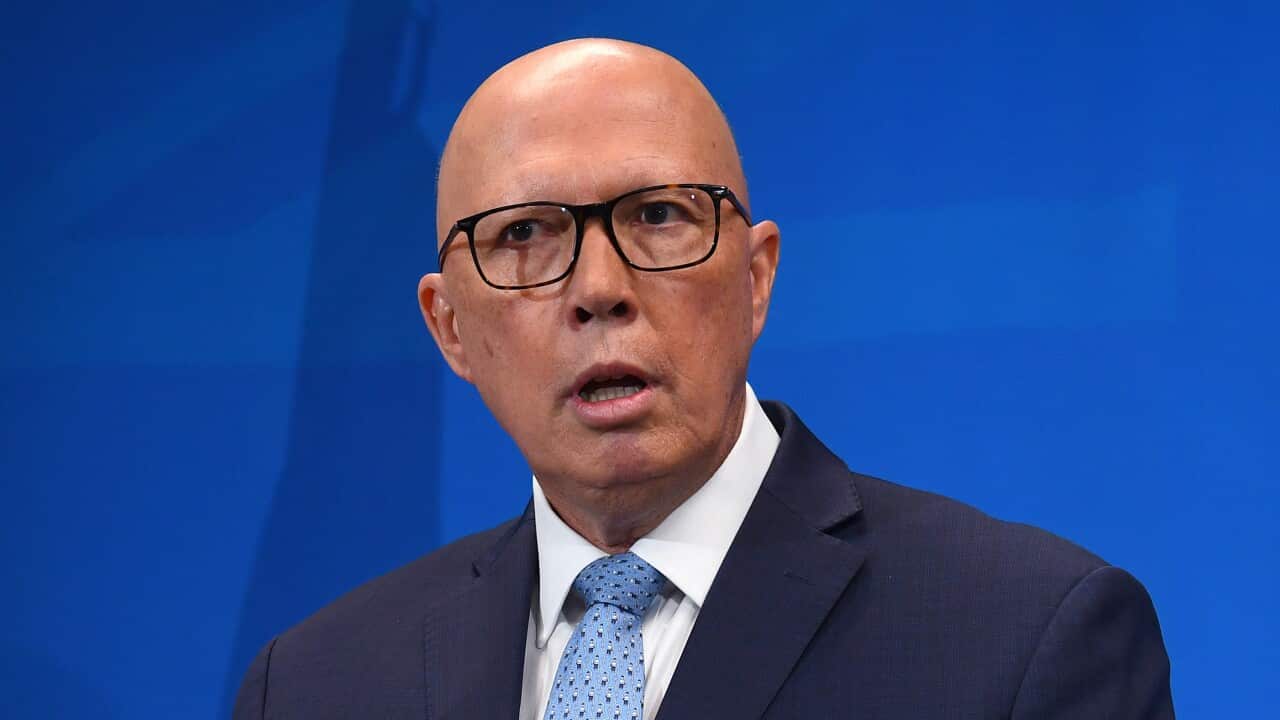 Peter Dutton stands at a lecturn that shows a sign saying 'Let's get Australia back on track'