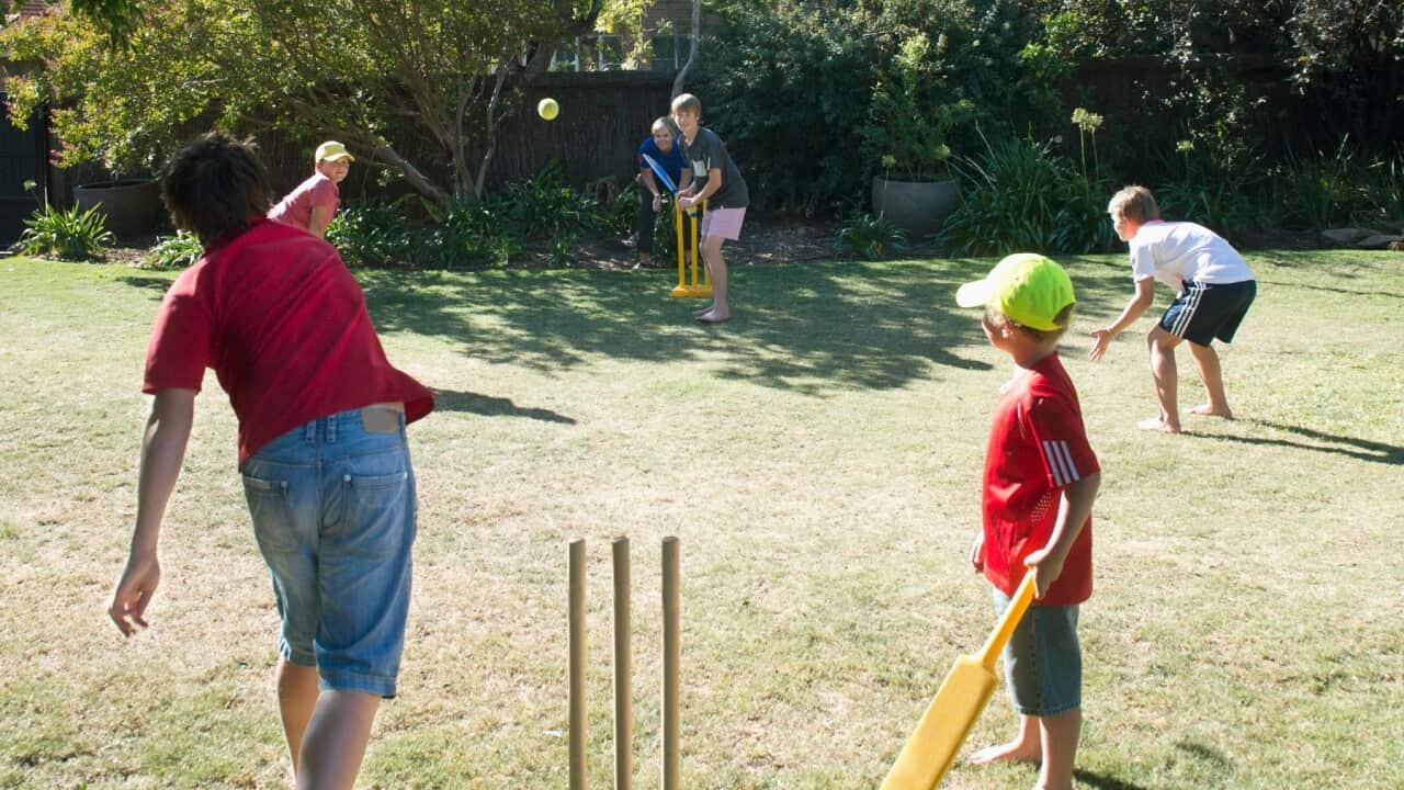 Arka bahçelerinde kriket oynayan çocuklar