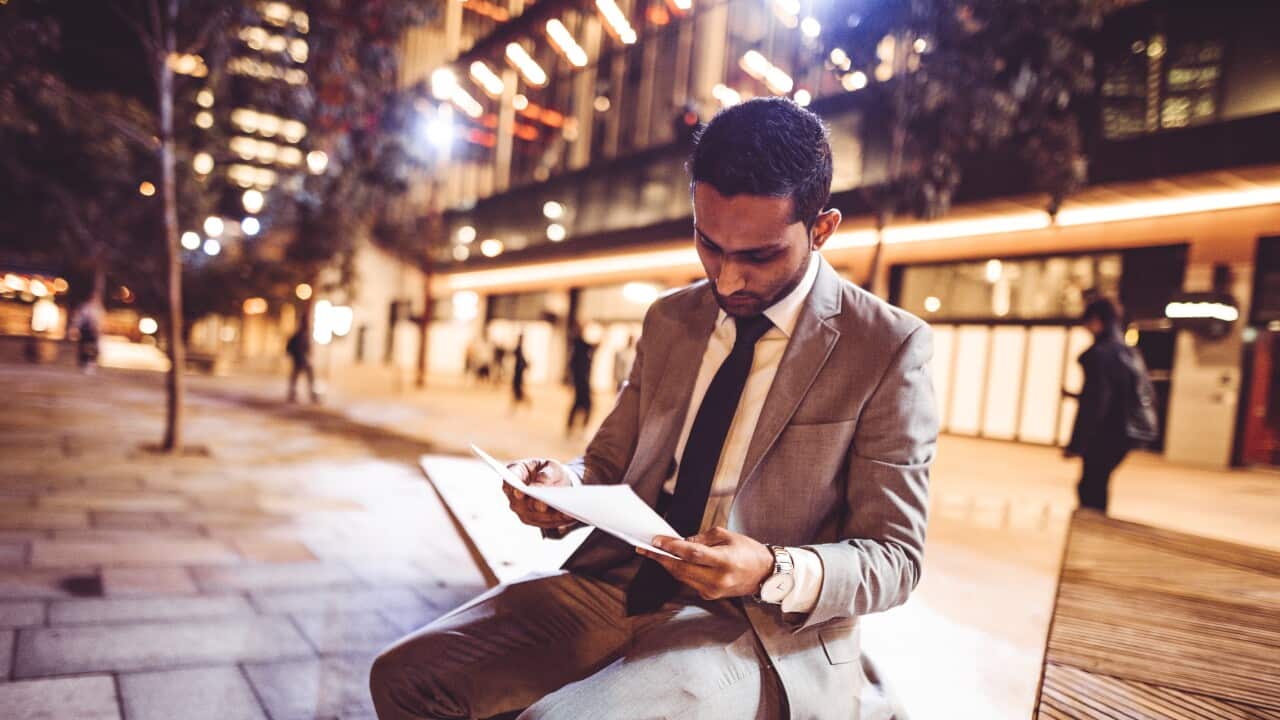 businessman on reading paperwork at night in the city