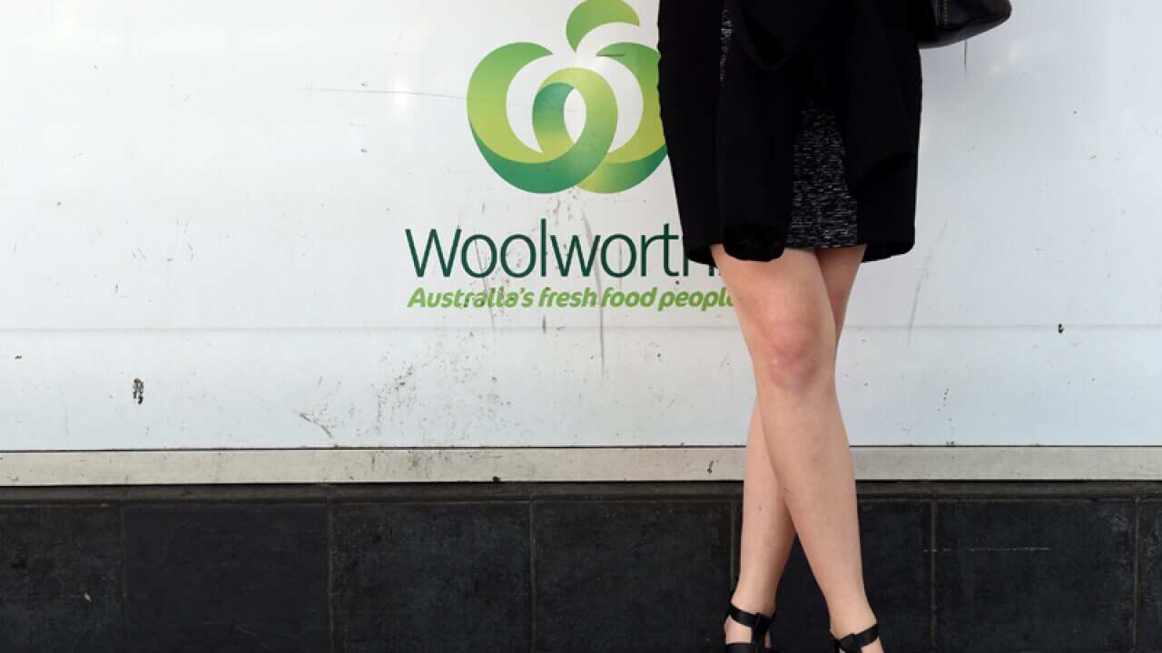 A customer stands outside of a Woolworths supermarket in Sydney