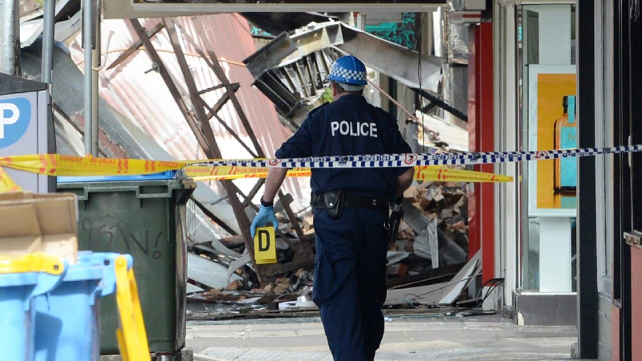 A NSW Police forensics photographer is seen on Darling Street