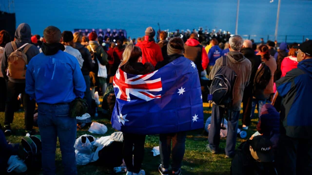 A pair draped with an Australian flag, participate in the Dawn Service ceremony at the Anzac Cove beach
