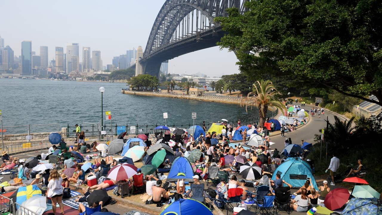 Revellers claim early harbourside positions at Kirribilli, ahead of the New Year's Eve fireworks, in Sydney, Tuesday, December 31, 2019. (AAP Image/Dan Himbrechts) NO ARCHIVING
