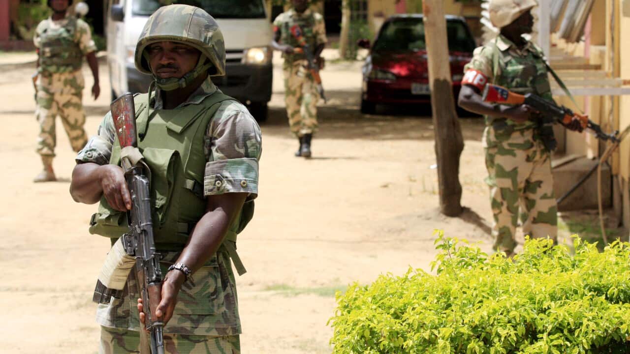 In this June 6, 2013 file photo Nigerian soldiers stand guard at the offices of the state-run Nigerian Television Authority in Maiduguri, Nigeria. (AP Photo/Jon Gambrell, File)