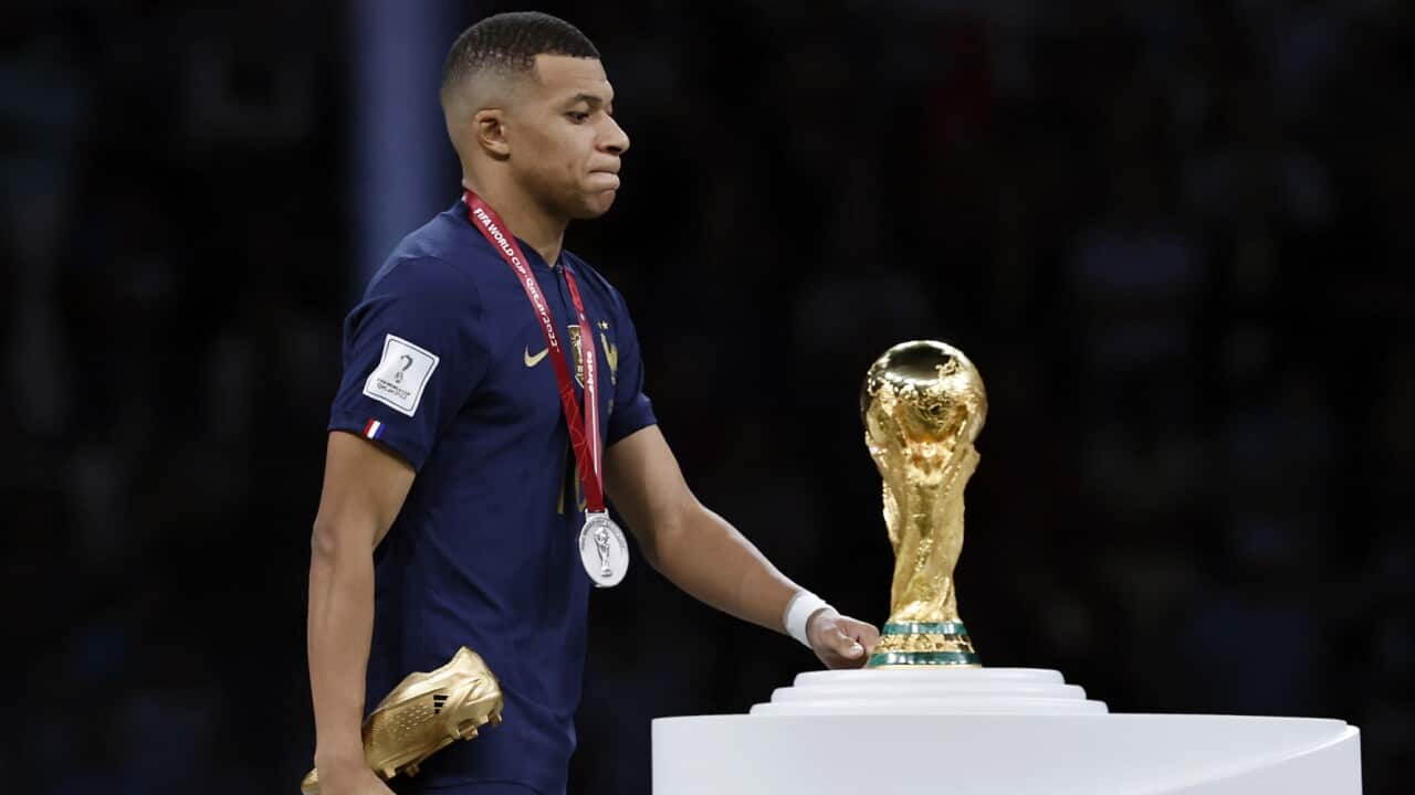 Kylian Mbappe walks past the FIFA World Cup trophy after losing the final with France