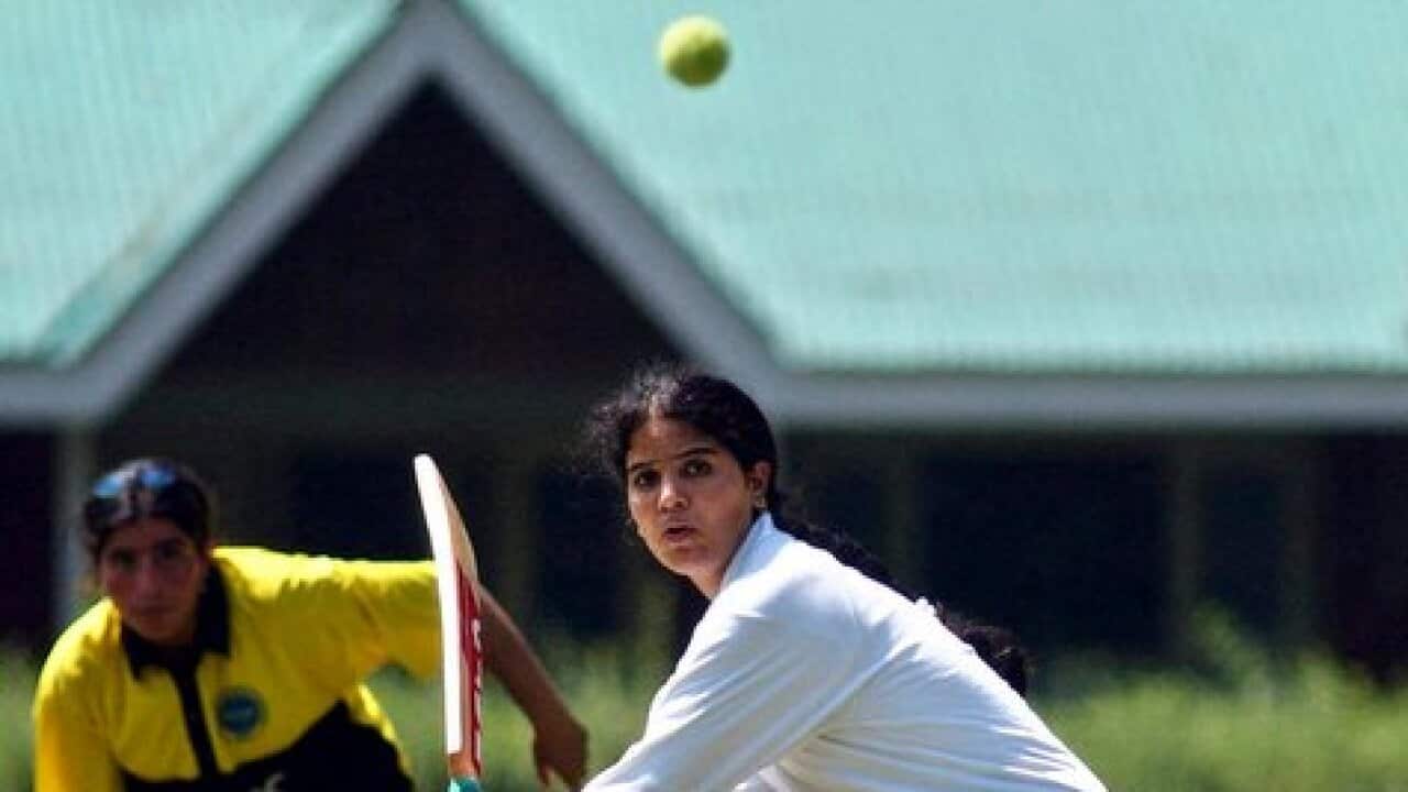 A Kashmiri college girl bats during an inter-college tennis ball cricket tournament