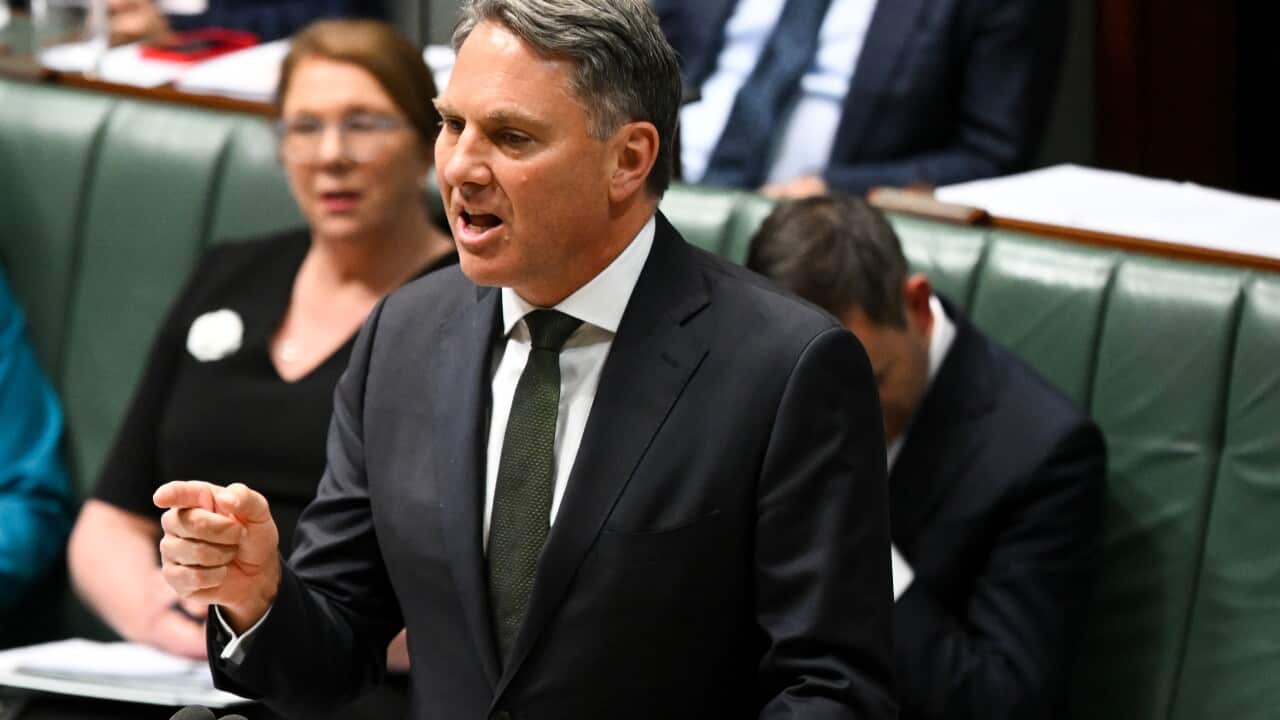 Man in suit speaks in the House of Representatives.