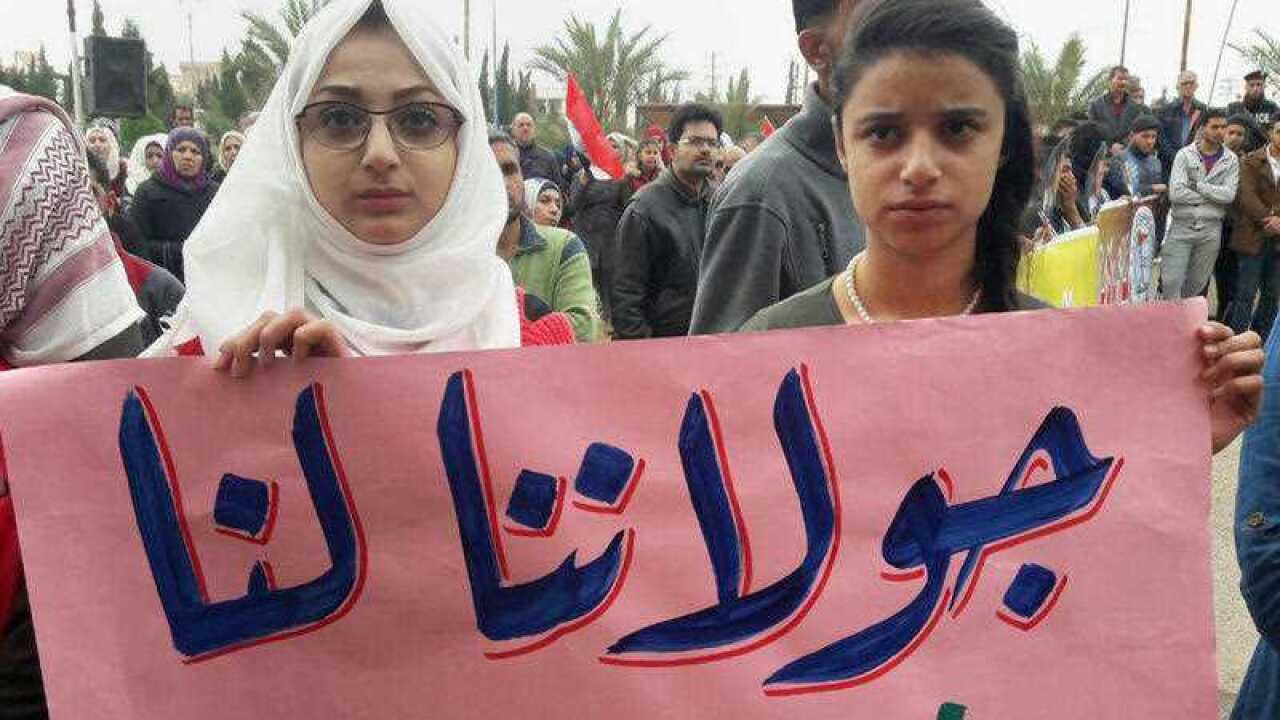 Syrians hold an Arabic banner 