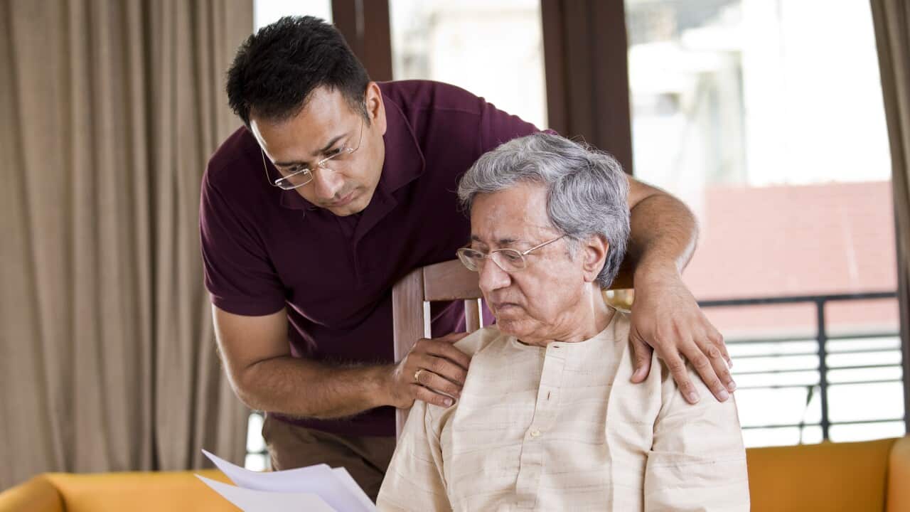 Man with old father reading a document at home