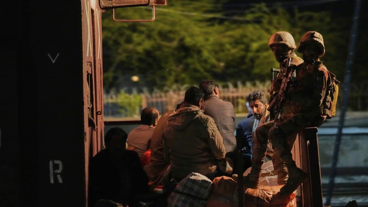 Soldiers and passengers seen on a train.