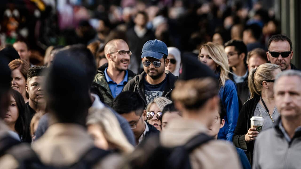 An image showing a crowd of people in a city.