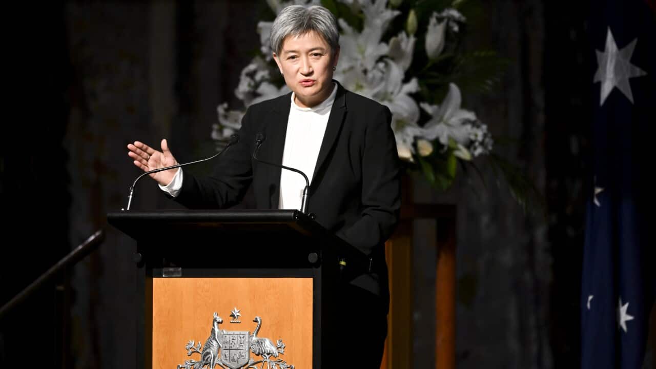 Woman stands at a podium.