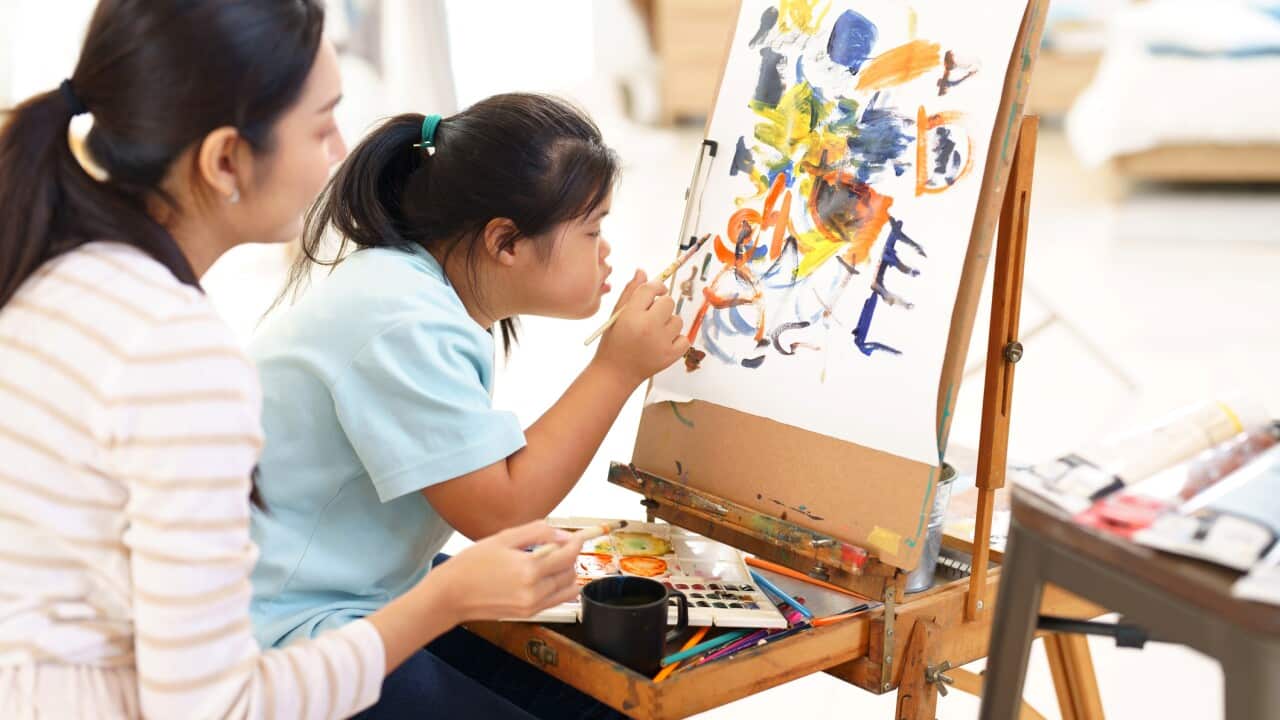 Mother teaching child practice painting for a hobby
