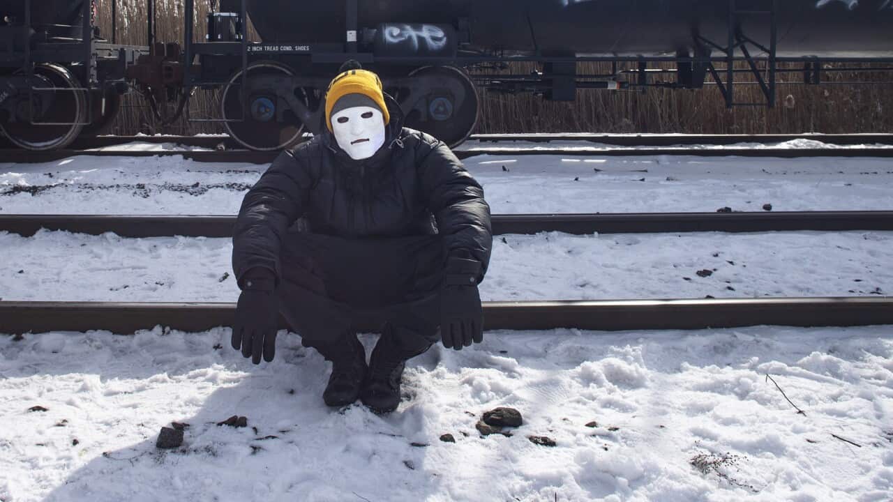 A protestor sits on train tracks during a blockade of a rail line Toronto.