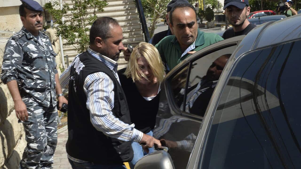 Lebanese policemen escort Australian TV presenter, Tara Brown, after she was taken from a Lebanese courthouse to Baabda Prison for women