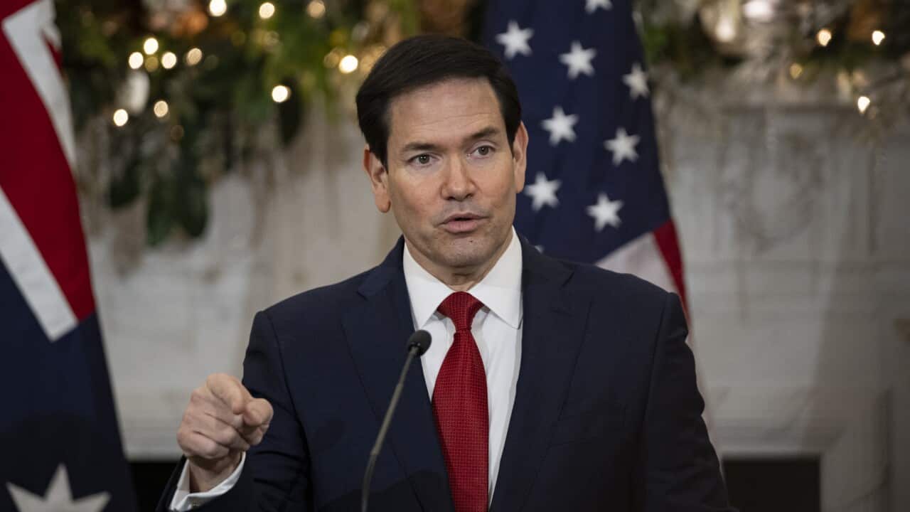 US Secretaries of State and Defense Marco Rubio speaking before a lectern and microphone