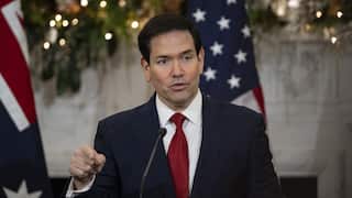 US Secretaries of State and Defense Marco Rubio speaking before a lectern and microphone