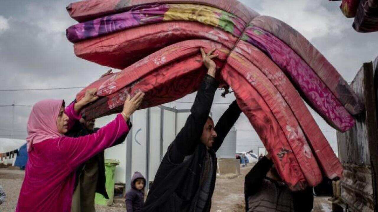 Iraqis leaving a refugee camp to return home to Mosul