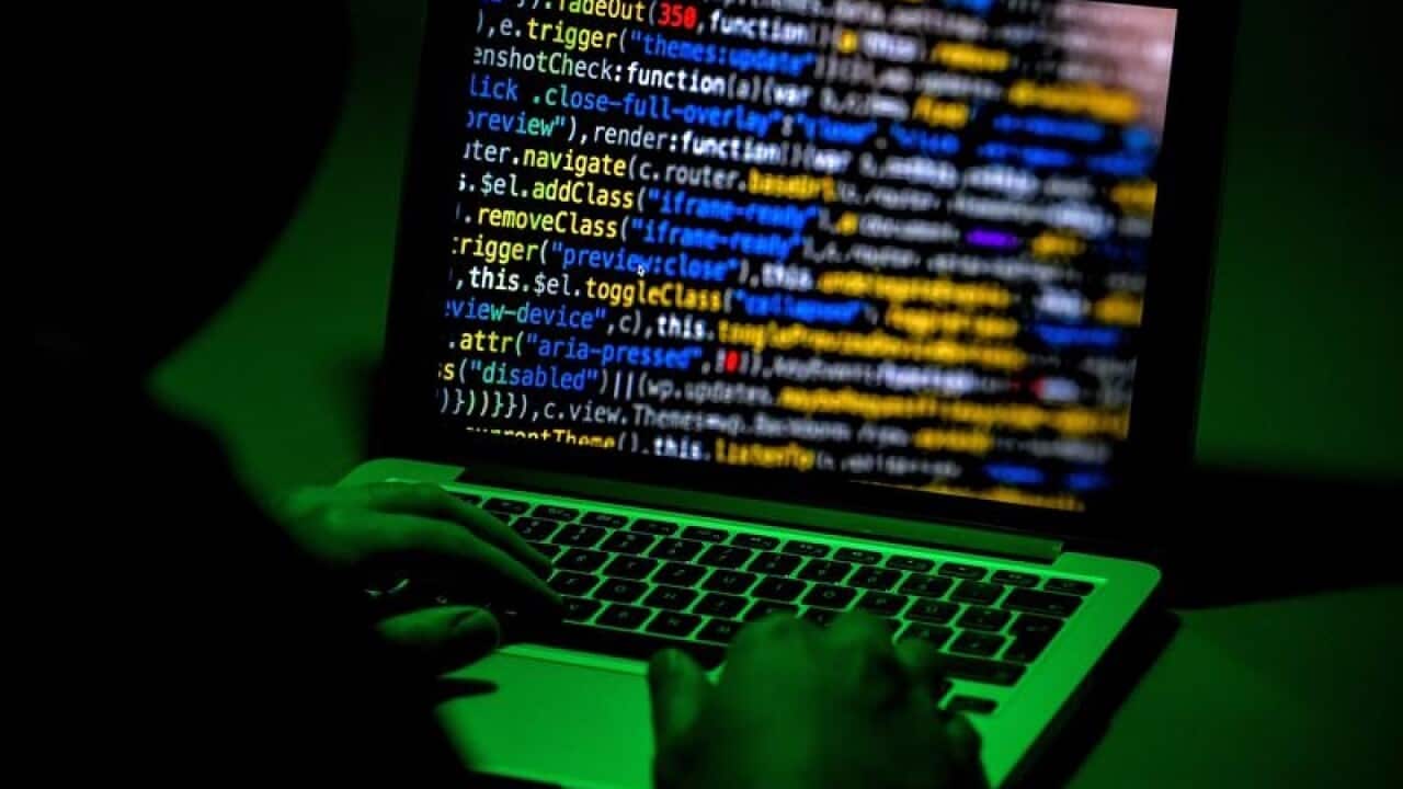 An image of a person sitting in front of a computer screen