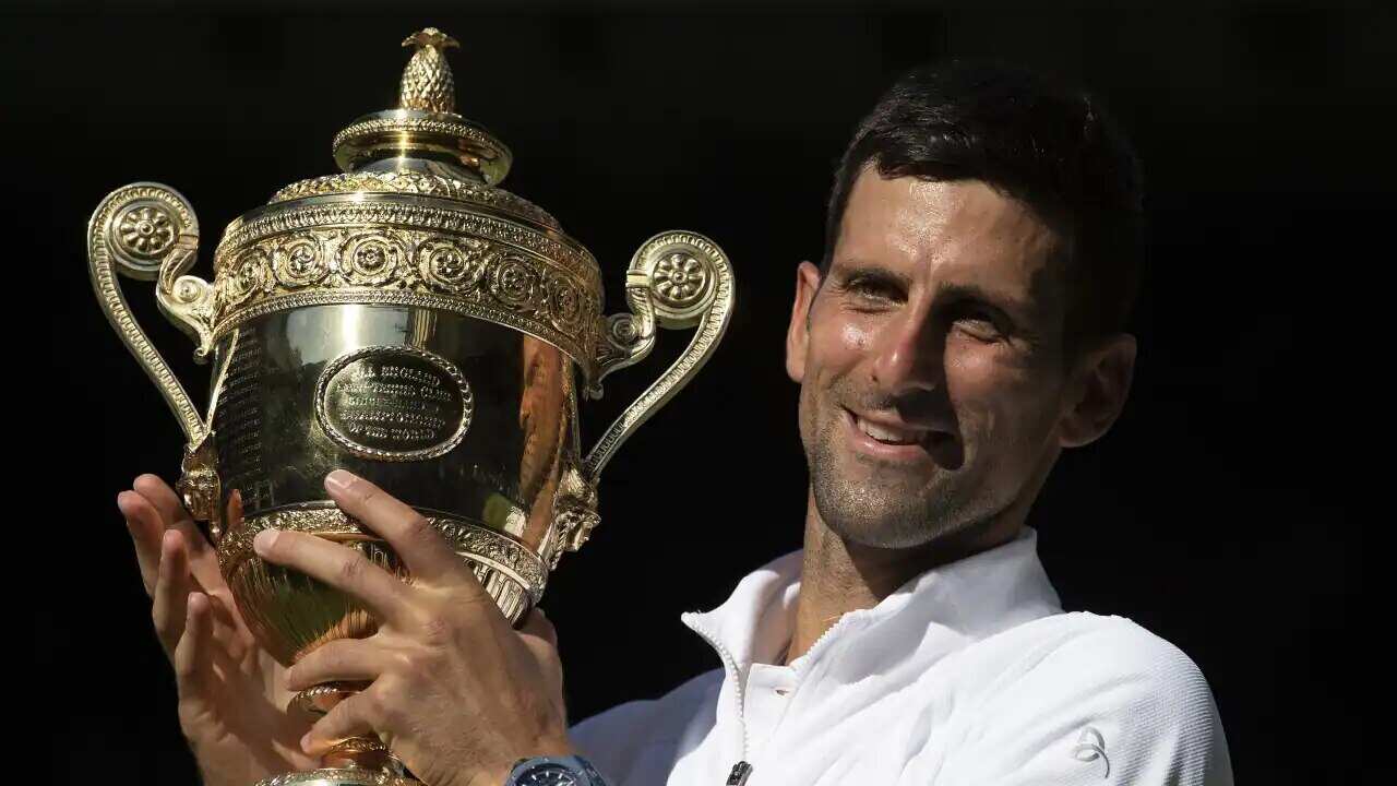 Novak Djokovic of Serbia poses for photographs with the winners trophy after victory over Nick Kyrgios.