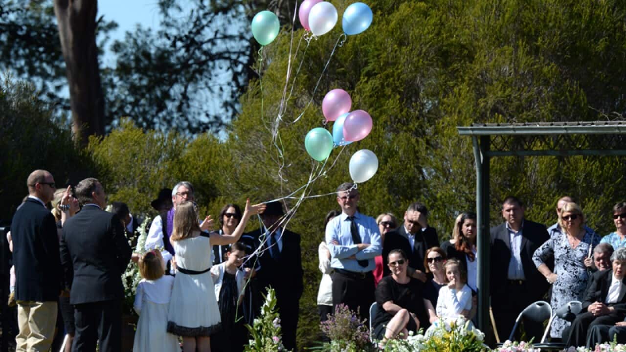 Balloons are released during a service for the Hunt family in Lockhart