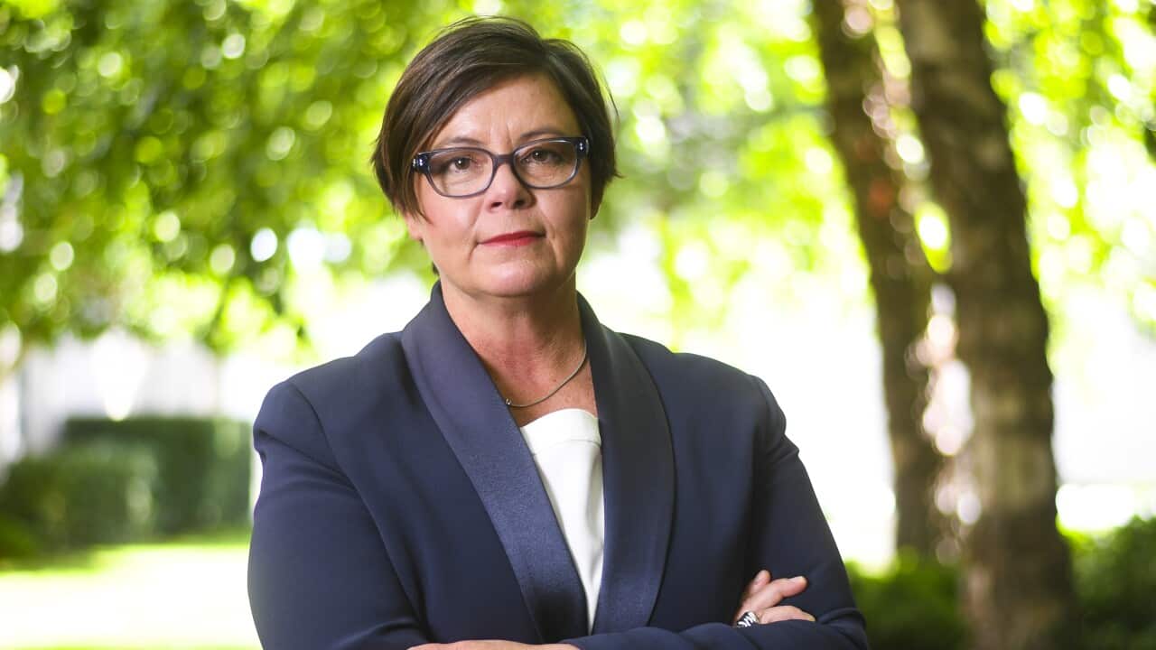 A woman standing with her arms folded.