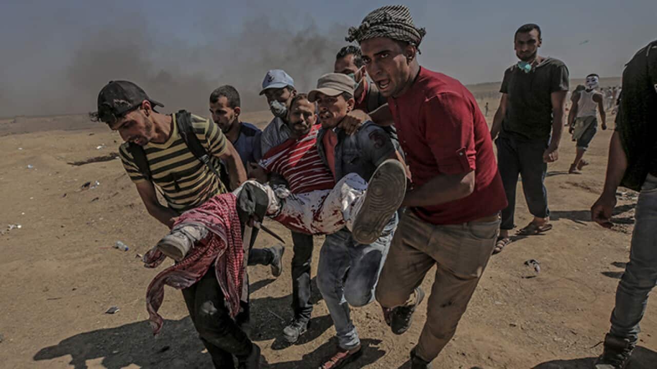 Palestinians protesters carry a wounder protester during clashes