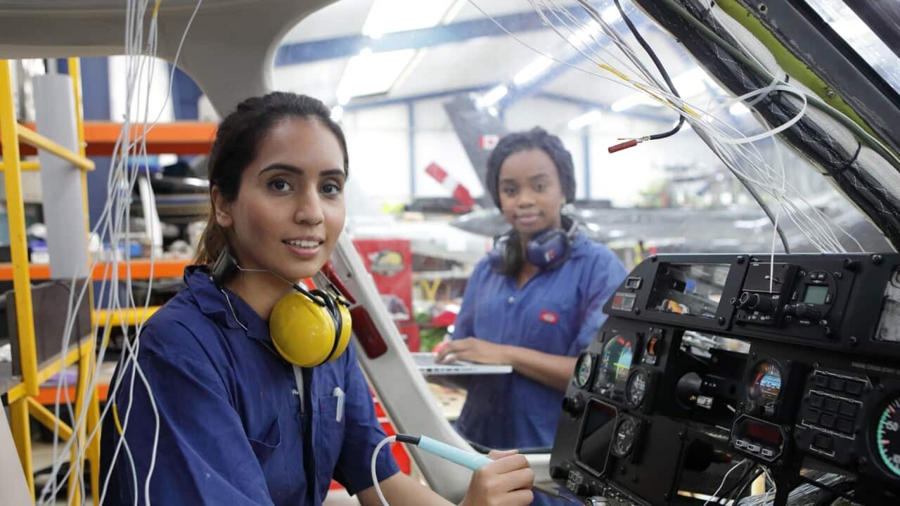 Young migrant engineers working on a helicopter (Getty)