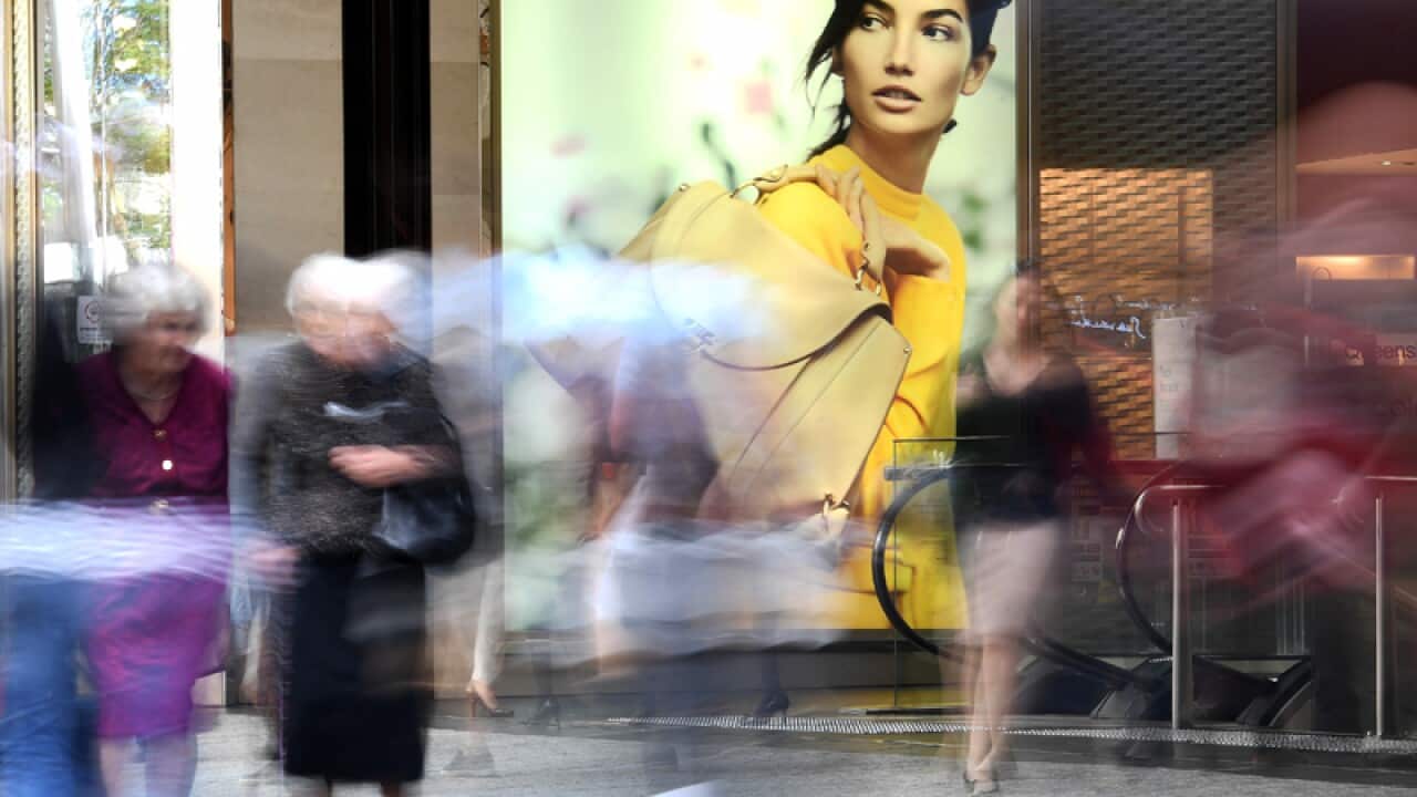 Shoppers walk past retail advertising in Brisbane