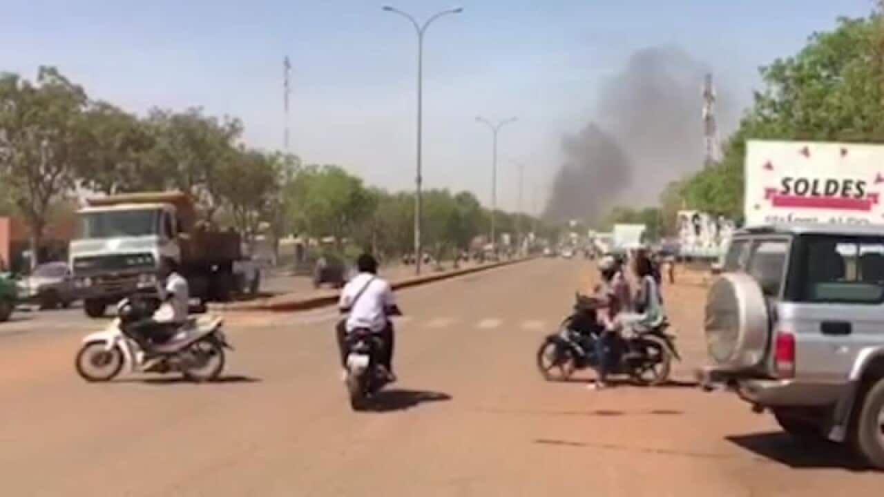 Smoke rises in the background in Ouagadougou during an attack by Islamic militant gunmen.